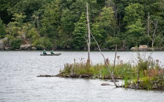 Anglers fishing from a boat on Olney Pond, Lincoln Woods State Park