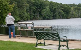 A man stands at the accessible fishing area at Lincoln Woods State Park