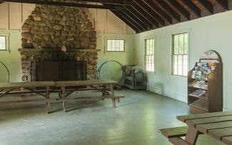 The interior of the historic cabin at George Washington Campground with a large fieldstone fireplace