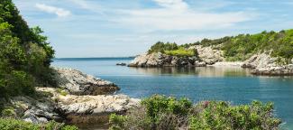 Blue waters of Narragansett Bay meet the rocky shoreline of Fort Wetherill State Park