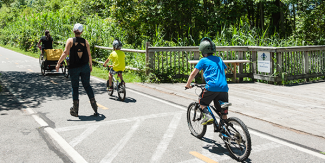 Group of kids on bikes and their grownup on roller blades on the East Bay Bike Path